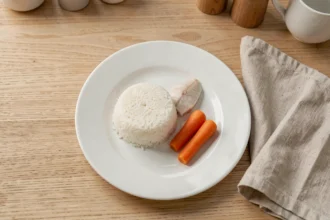 Assiette de riz blanc, poisson vapeur et carottes cuites pour un régime sans résidu avant coloscopie